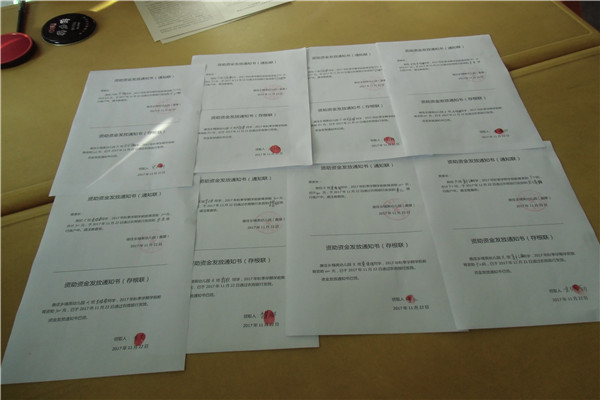 受助家长在签字 教师指导家长签名 资助资金发放通知书 家长们手握现金,心里充满感激之情! 为贯彻落实党和国家提出的不让一名学生因家庭经济困难而失学和精准资助工作目标,认真做好家庭经济困难学生的资助工作,11月22日下午,唐庄精英幼儿园举行了贫困幼儿资助金发放签字仪式。 为确保此项活动让贫困家庭感受到这一惠民政策的温暖,该园安排专人负责,严格规范操作,按照公平、公开、公正的原则办理,通过宣传摸底、家长申请、村乡两级证明、班主任上报、园评审小组审核、公示等程序,严格把关、层层筛选。确定了14