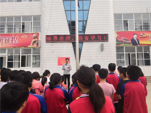 登封市聋哑学校的全体教师在国旗下举起右手庄严宣誓:我志愿做一名