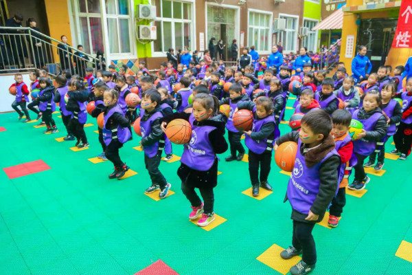 主持人开场 亲子游戏 旗手护旗手入场 教师篮球节目 集体操展示 师幼篮球操 幼儿篮球操进行中 为了丰富幼儿的生活,提高幼儿参与体育活动的兴趣,发展幼儿动作的协调性和灵活性,使幼儿身体得到锻炼、体质得到增强;同时,加强家长与幼儿之间的情感交流,体验合作与亲子交往的快乐。金摇篮幼儿园在2018年11月14日开展了主题为健康运动,快乐成长亲子运动会。 亲子运动会在上午9:00准时开始,运动场上精彩纷呈。开幕式上高潮迭起,活力四射,小运动员们在老师的主持号召下,拍着双手,踏着脚步,雄赳赳、气昂昂地