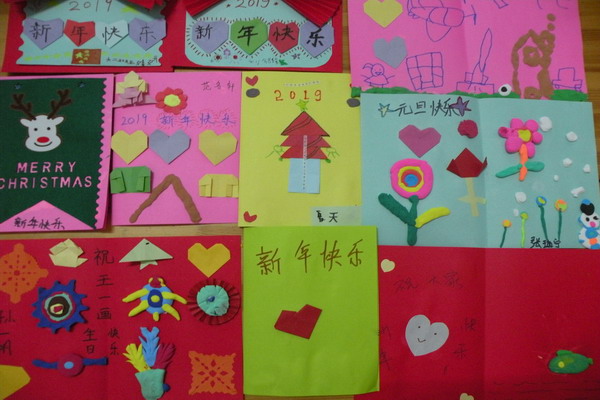手工制作现场 家长和孩子认真制作 看,我做的灯笼漂亮吗? 漂亮的贺卡 绘本交流 颁奖 为了让孩子们感受新年来临的喜悦气氛,培养幼儿的想象力、创造力及动手操作能力,增进幼儿与家长的情感,体验亲子活动的乐趣。12月29日下午,市直二幼开展了迎新年、庆元旦亲子手工制作活动。 活动前,各年级结合幼儿特点,全面预设活动方案,老师们通过家园联系栏、微信群等方式与家长进行沟通,制定班级的制作内容。 灯笼是喜庆的象征,预示着红红火火,团团圆圆。小班年级组根据孩子的年龄特点邀请家长同孩子们一起装饰、制作灯