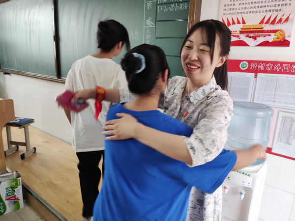 登封市外语语高中弋安琪老师和学生深情拥抱_副本.jpg